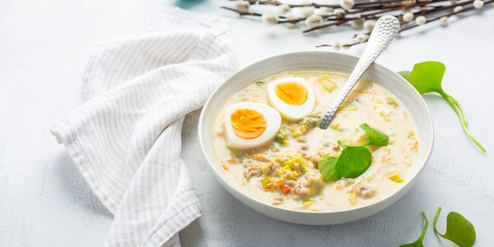 Traditional Polish sour soup Zurek in ceramic bowl for Easter