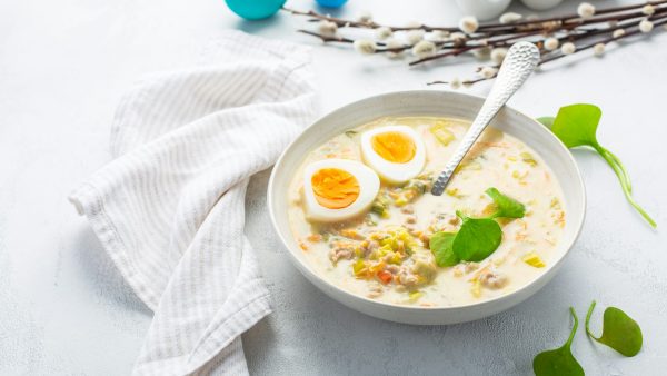 Traditional Polish sour soup Zurek in ceramic bowl for Easter