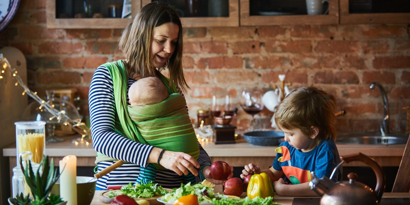 Young family, mother with two children cooking at home