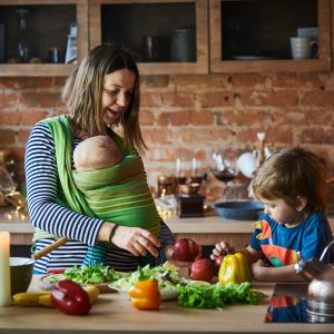 Young family, mother with two children cooking at home