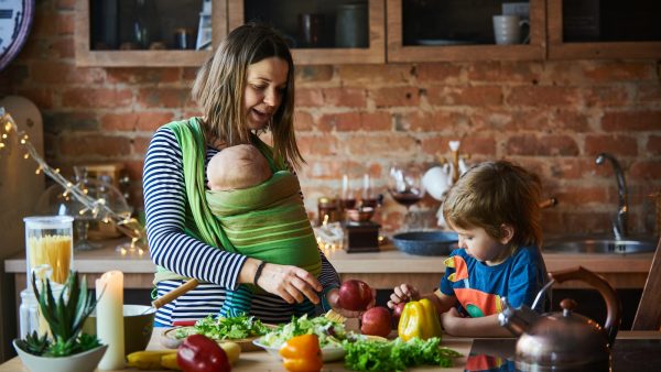 Young family, mother with two children cooking at home