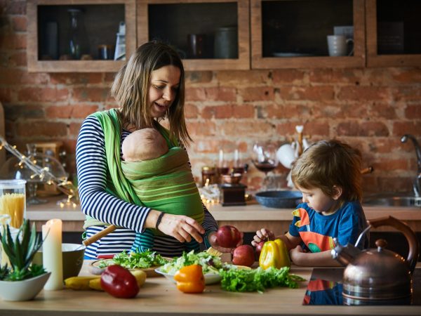 Young family, mother with two children cooking at home