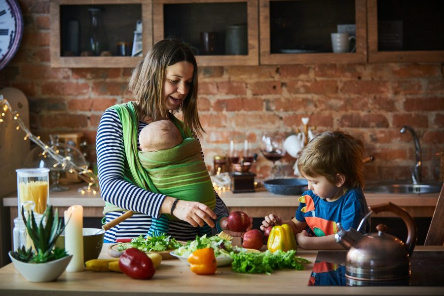 Young family, mother with two children cooking at home