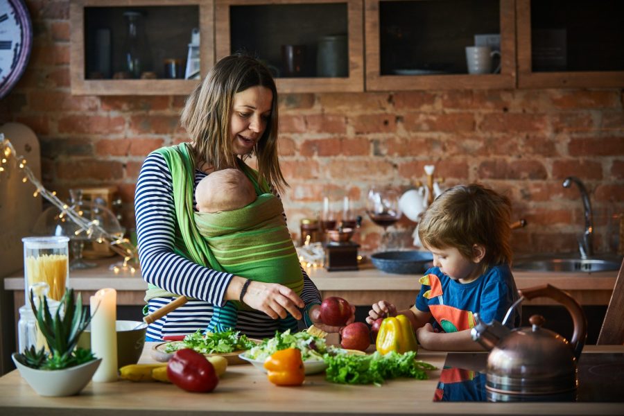 Young family, mother with two children cooking at home